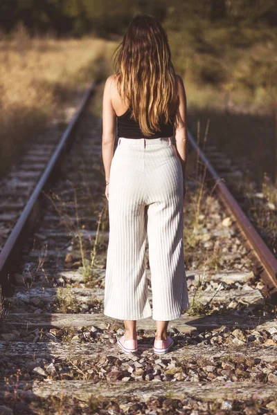 Staromodna fotografia. Tylny widok kobiety stojącej na torach kolejowych. koncepcja wyboru lub pamięci. — Zdjęcie stockowe