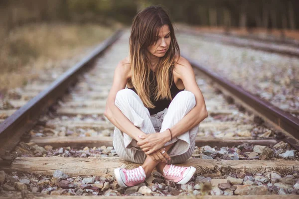 Retrato de una joven triste, Sentado al aire libre en la vía férrea . — Foto de Stock