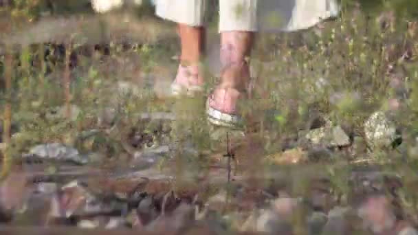 Mujer joven de moda caminando en la vía férrea . — Vídeos de Stock