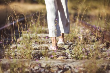 Eski moda fotoğrafçılık. Tren raylarının üzerinde duran bir kadının arka görüntüsü. Seçim konsepti veya anılar.
