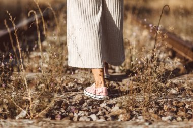 Eski moda fotoğrafçılık. Tren raylarının üzerinde duran bir kadının arka görüntüsü. Seçim konsepti veya anılar.