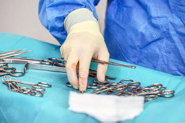 Close-up de enfermeira de esfoliação tomando instrumentos médicos para operação com colegas que atuam em segundo plano . — Fotografia de Stock