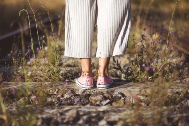 Eski moda fotoğrafçılık. Tren raylarının üzerinde duran bir kadının arka görüntüsü. Seçim konsepti veya anılar.