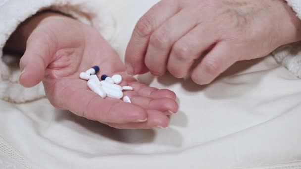 Mujer mayor que toma medicamentos, toma pastillas de la mano, vista de cerca . — Vídeo de stock