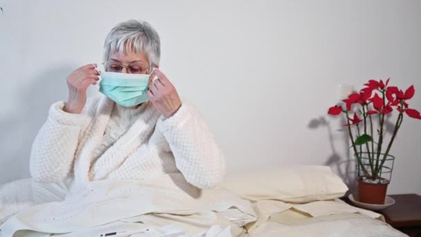 Covid-19. Oudere vrouw met gezichtsbeschermingsmasker, risicopatiënt, bescherming tegen coronavirusgriep en verkoudheid. — Stockvideo