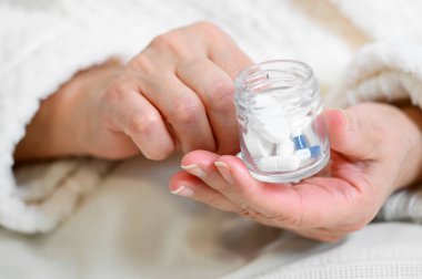 Şişeden hapları döken yaşlı kadın, yakın çekim..