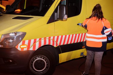 Tanımlanamayan bir sağlık görevlisi, ambulans şoförü, acil bir durum için hazır..