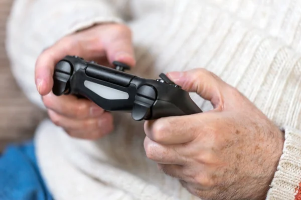 Close-up de mão sênior segurando controlador de jogo de vídeo . — Fotografia de Stock