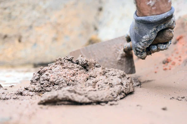 Pekerja konstruksi tangan Man menggunakan sekop untuk mencampur mortir. — Stok Foto