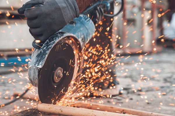 İnşaat işçisi inşaat alanında Öğütücü Kesici Metal kullanıyor..