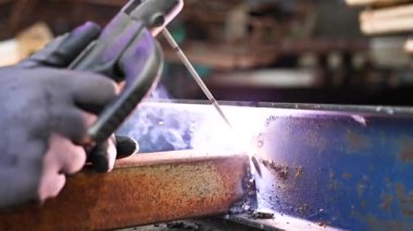 Ağır çekimde iki metal parçasının kaynak işlemine yakın çekim.