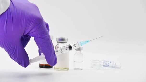 Φαρμακοποιός επιστήμονας παίρνει μια σύριγγα. Έρευνα εμβολίων κατά του ιού του κερατοειδούς. Φιαλίδια φαρμακευτικής σε λευκό φόντο. — Αρχείο Βίντεο