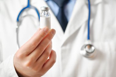 Beyaz önlüklü doktor ellerinde aşı öneriyor. İlaç. İlaç tedavisi. Seçici odak.