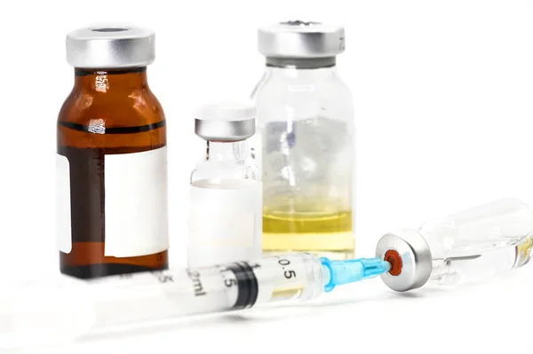 Pandemia de coronavírus, conceito de vacinação de pessoas. Seringa de vacina com frascos para injetáveis, medicamentos de perto sobre fundo branco . — Fotografia de Stock