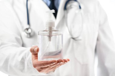 Tıbbi üniformalı doktor, koronavirüsün yayılmasını önlemek için hastaya dezenfektan veriyor. Covid-19 koruma, tıbbi bilgiler. 