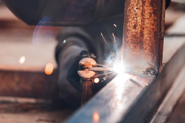 Close-up of the welding process of two metal parts. Industrial background.