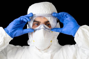 Covid-19 koruyucu ekipman. Doktor ya da erkek hemşirenin portresi siyah izole edilmiş arka plan üzerine kişisel koruma giysisi..