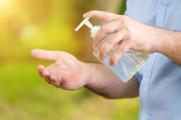 Man hands using wash hand alcohol gel or sanitizer bottle dispenser, against coronavirus disease Covid-19 . Antiseptic, Hygiene and Health concept.