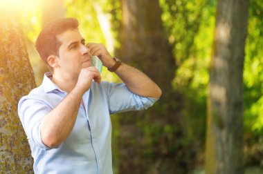 Korunaklı yüz maskesi takan genç adam dışarıda açık havada Coronavirus 'a karşı zaferi kutluyor. Karantina sona erdi. Maskeyi çıkar. Açık havada. Özgürlük için. Covid-19. Salgın krizi sona erdi..