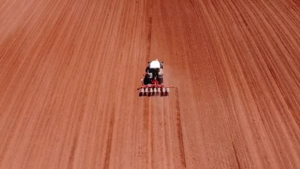 Výsev zemědělců, výsev plodin na poli s traktorem. Výsev je proces výsadby osiva v půdě v rámci zemědělské činnosti. — Stock video