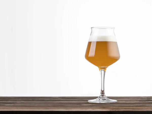 白色背景下隔离的木制桌子上的一杯啤酒左手边有复制空间的水平构图 — 图库照片
