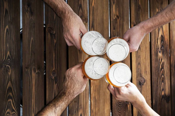 Dört elin üst görüntüsü, tezahürat yapan ve birlikte eğlenen, ahşap masa, solunda fotokopi alanı olan.