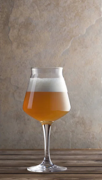 木桌上的一杯啤酒 背景中的石头垂直构图 — 图库照片