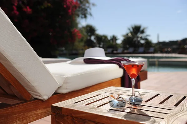 Havuz kenarında lüks bir otelde dinleniyor.