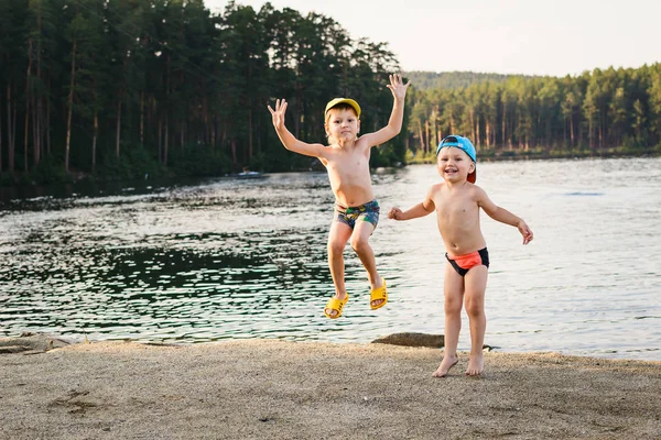 Два мальчика прыгают на озере — стоковое фото