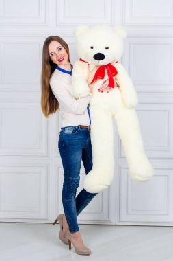 büyük bir oyuncak ayı tutan kız. Kot ve beyaz tam uzunlukta gömlek büyük beyaz oyuncak ayı ile bir genç kadın. Silah, reklam oyuncak ayılar stüdyo