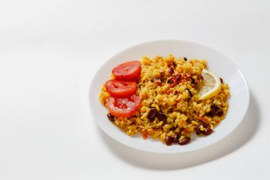 Bulgur Pilavı ile fasulye, kızamık, kırmızı biber, sarımsak, domates, limon ve beyaz zemin üzerine baharat