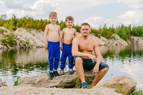 Apa és két fia félmeztelen a parton a tó nyár. — Stock Fotó