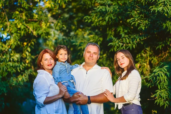 Família feliz de quatro pessoas na floresta em um passeio — Fotografia de Stock