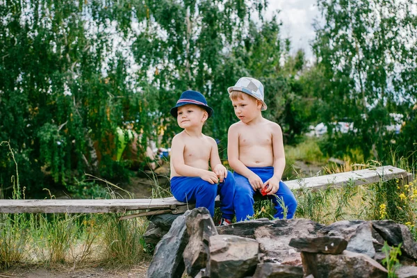 Dois meninos de calças e chapéus azuis — Fotografia de Stock