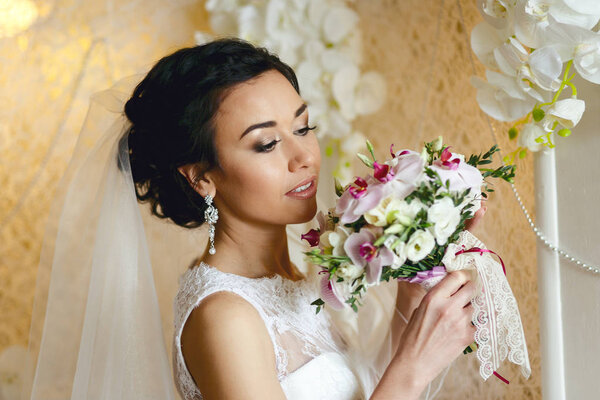 Брюнетка невеста со свадебным букетом
