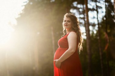 Yaz aylarında Kırmızı elbiseli genç hamile kadın
