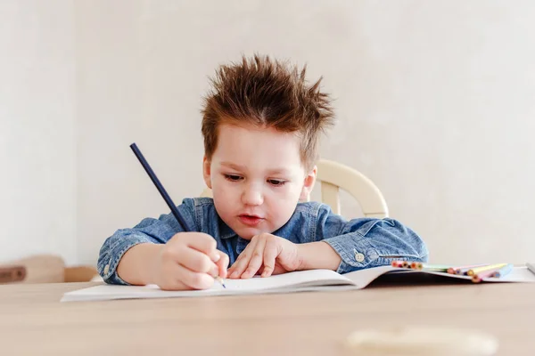 Petit garçon dessine avec un crayon à la table — Photo