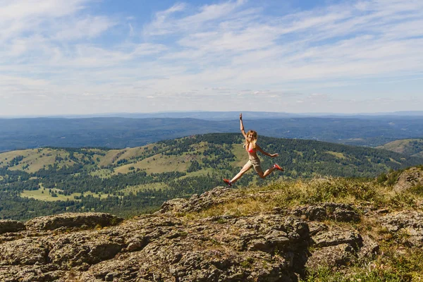 Девушка прыгает высоко в горах — стоковое фото