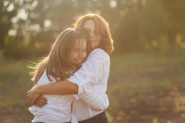 Mãe feliz com sua filha abraçando um adolescente no verão — Fotografia de Stock