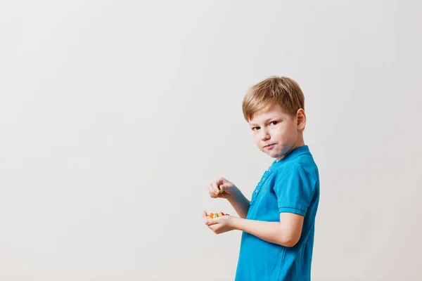 Chłopiec zjada Ananasy kandyzowane na białym tle — Zdjęcie stockowe