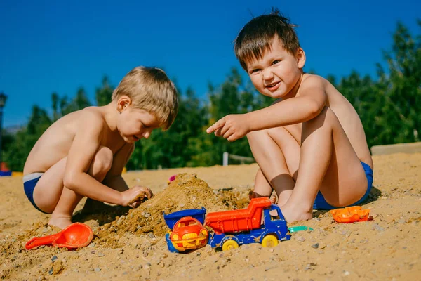 Два мальчика играют в песке на пляже — стоковое фото