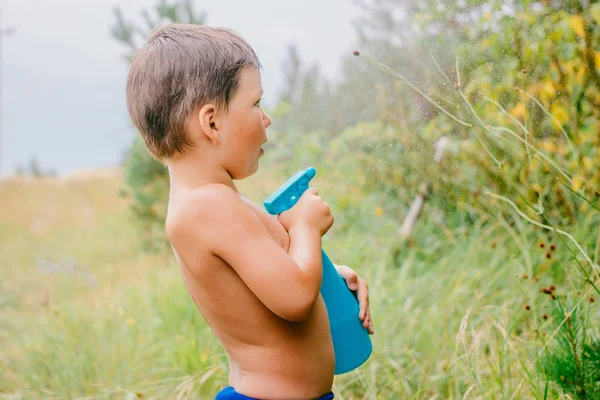 Маленький удивленный мальчик брызгает водой — стоковое фото