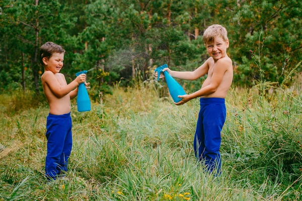 Boldog fiúk fröccsenő víz nyári erdőben — Stock Fotó