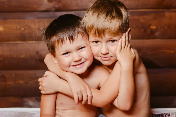 Два счастливых мальчика на деревянном фоне — стоковое фото