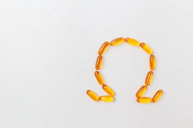 Beyaz arka planda turuncu balık yağı kapsülleri