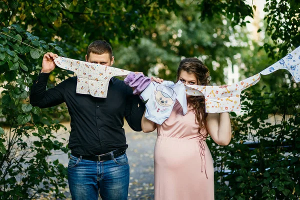 Hamilelik, bebek giysileri ile evli genç Çift — Stok fotoğraf
