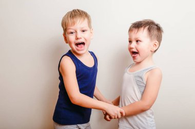 iki neşeli küçük çocuklar birlikte oynamak, elleri ve çığlık tutun