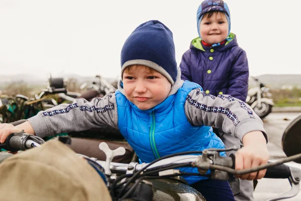 Two boys playing on a retro motorcycle — Stock Photo, Image