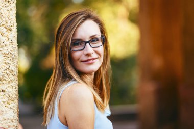 Neşeli mutlu çekici genç kadın otuz yaşında yaz aylarında sokakta gözlüklü