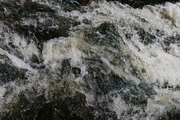 Bubblande vatten i strömmen med skum — Stockfoto